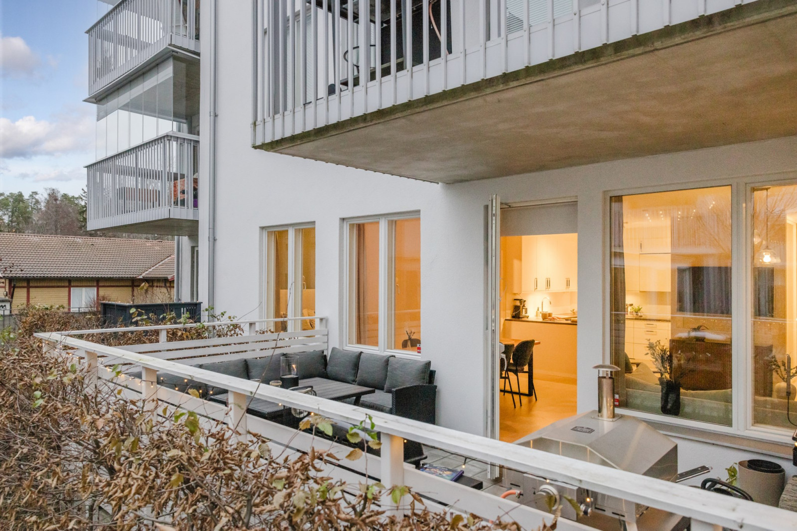 Generös uteplats som inhängnas av staket och häckar Rönninge Torg 13