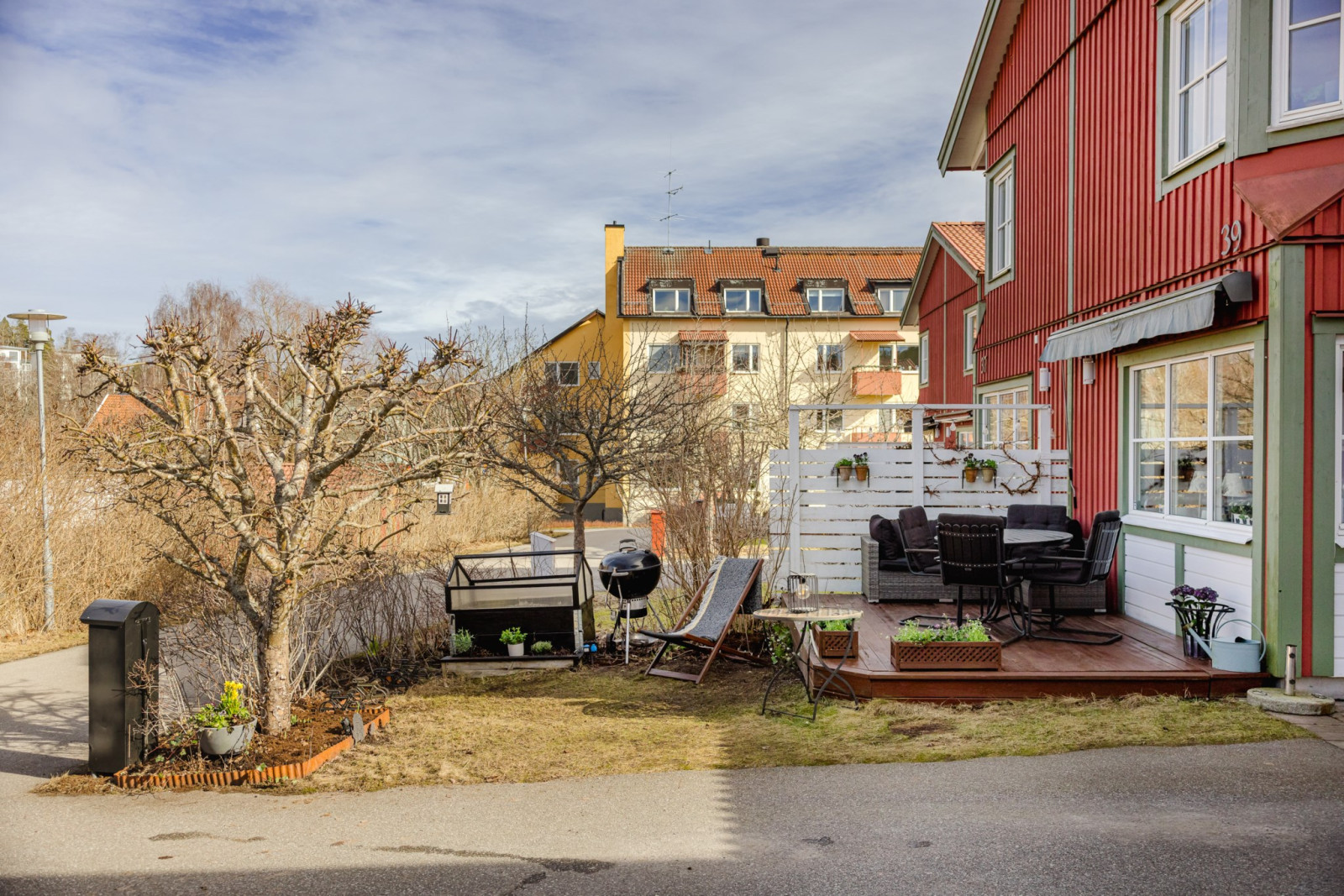 Framsida med gräsmatta, grönska och uteplats Westerdahlsvägen 39